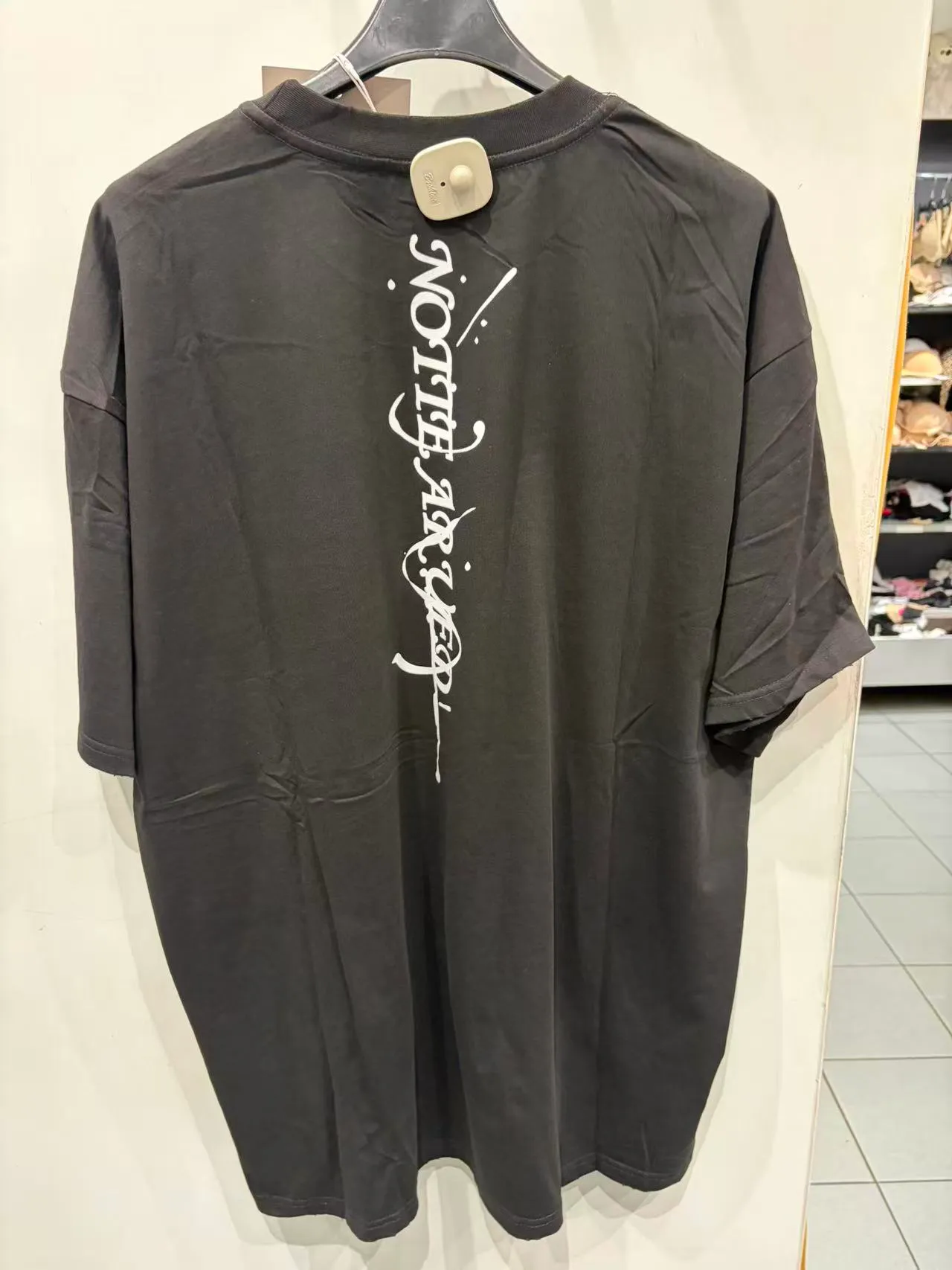 T-shirt oversize nera con stampa grafica bianca verticale, vista posteriore