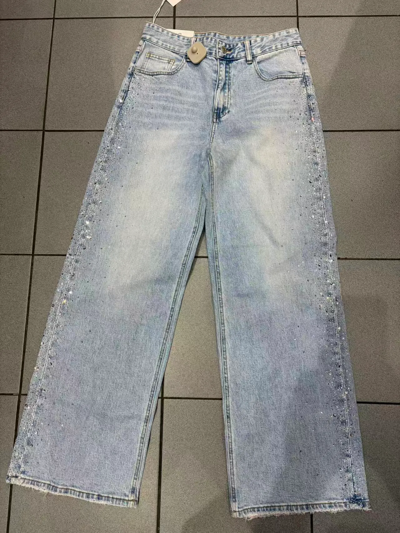 Jeans azzurri a gamba larga con strass sui lati e orlo grezzo, vista frontale