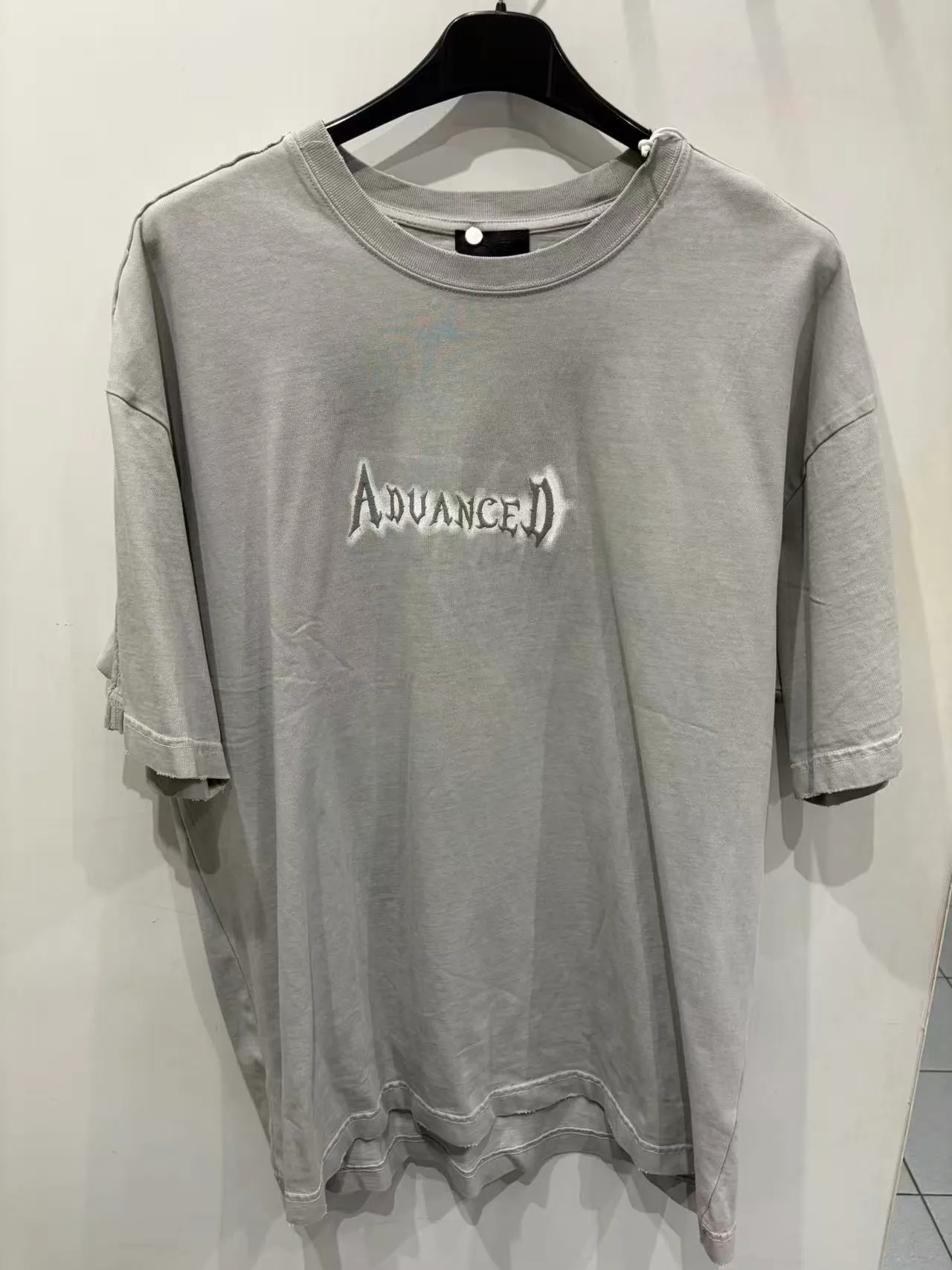 T-shirt grigia oversize con piccola grafica bianca, vista frontale