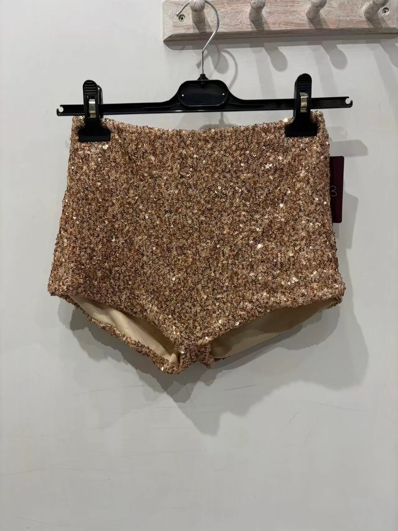 Pantaloncini a vita alta rosa oro interamente decorati con paillettes, vista frontale
