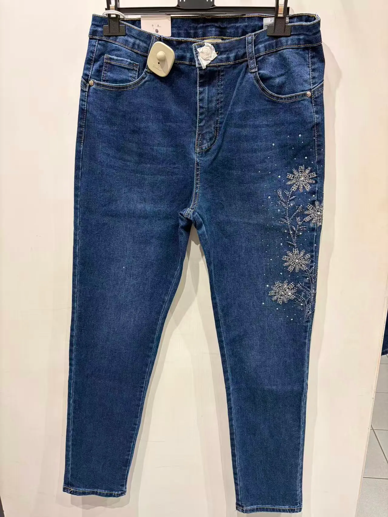 Pantaloni blu slim con dettagli floreali chiari, vista frontale