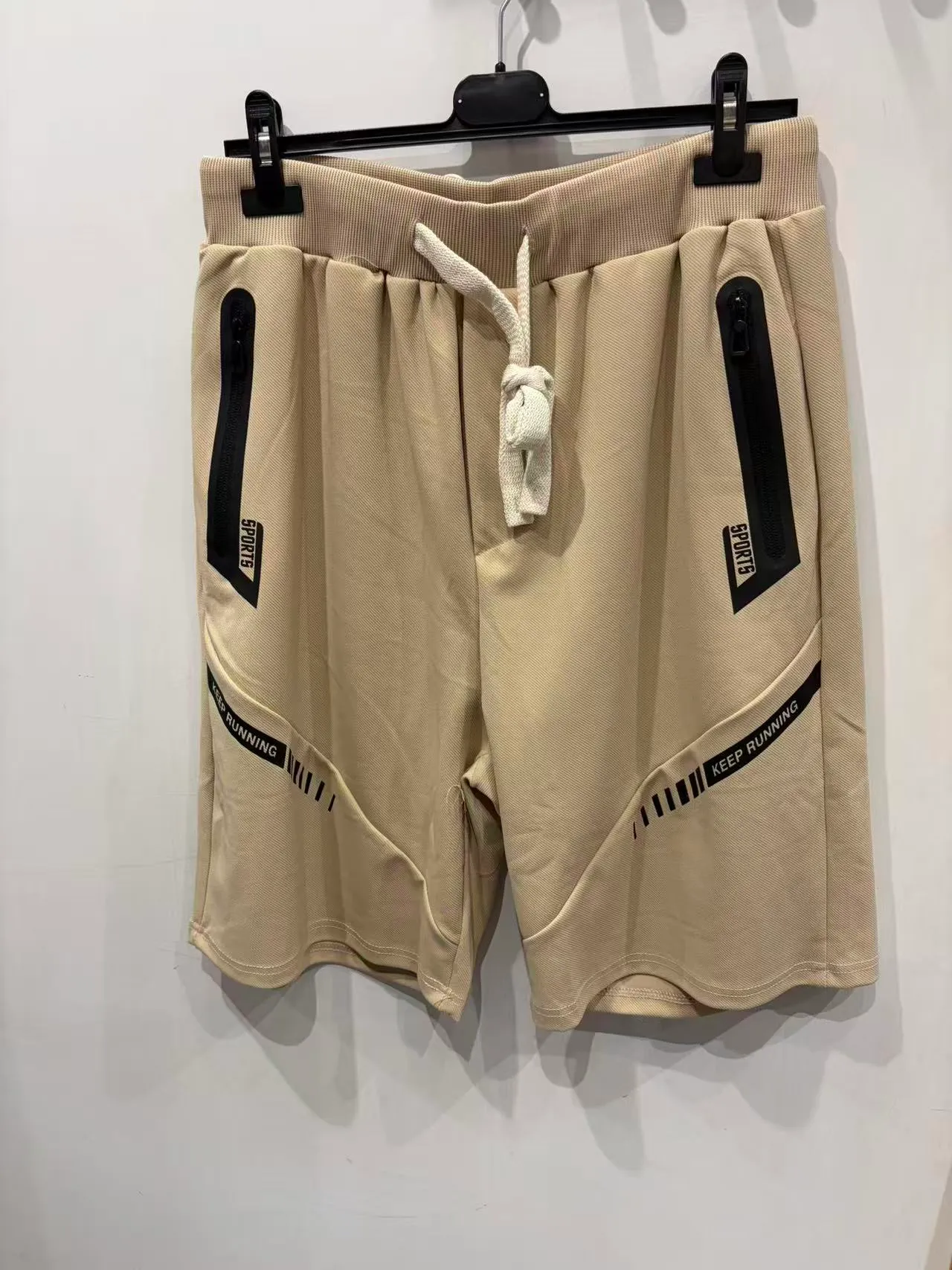 Pantaloncini beige con coulisse e tasche con zip nere, vista frontale