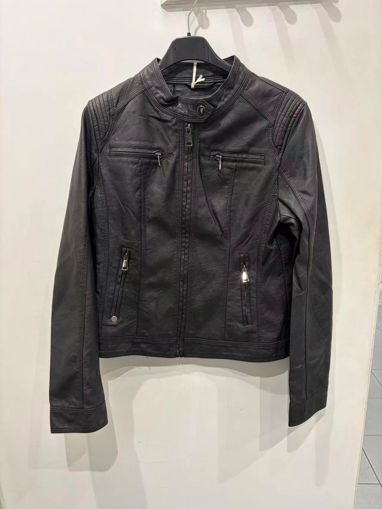 Giacca biker nera in ecopelle con tasche con zip e spalle trapuntate, vista frontale