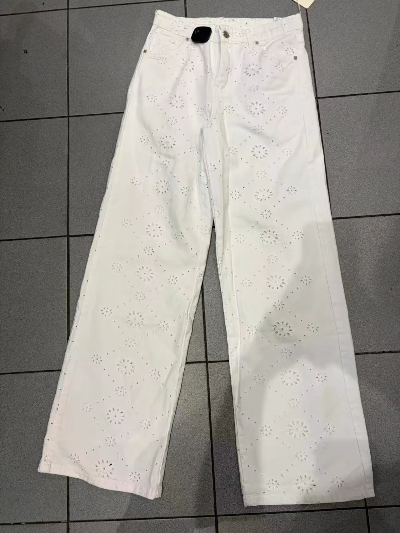 Pantaloni bianchi a gamba larga con ricamo floreale traforato, vista frontale