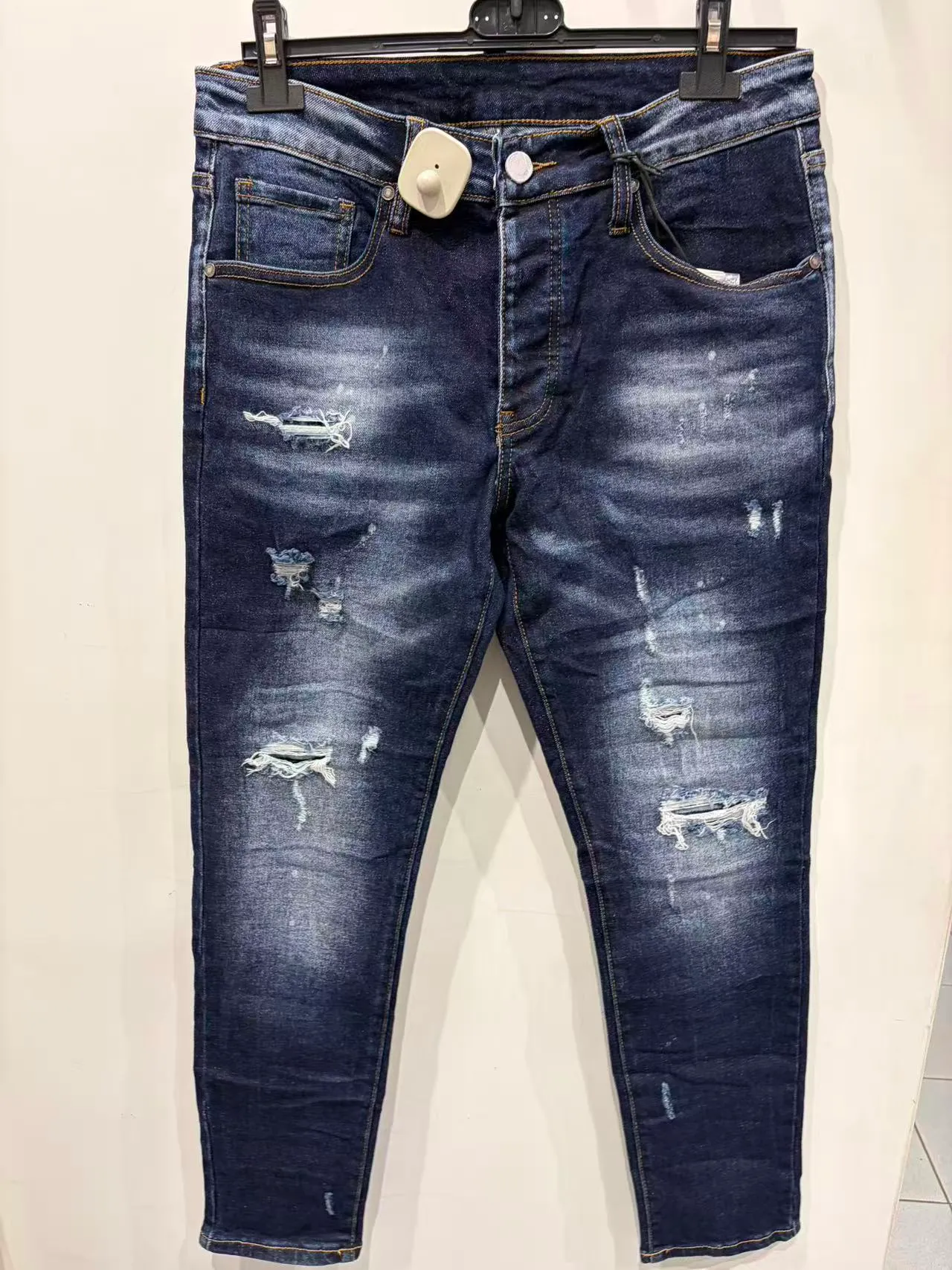 Jeans slim blu scuro con lavaggio sfumato e dettagli strappati, vista frontale